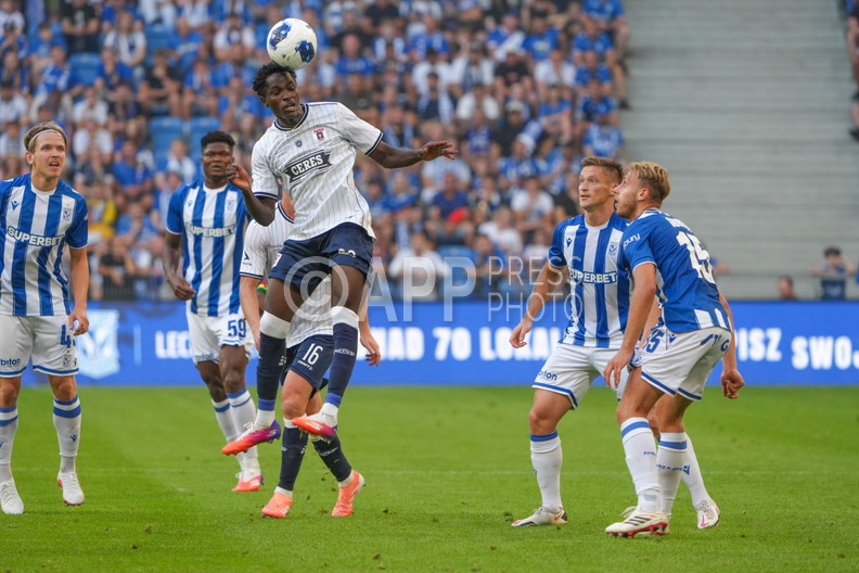 James Bogere walczy o pilke z pilkarzami Lecha Poznan